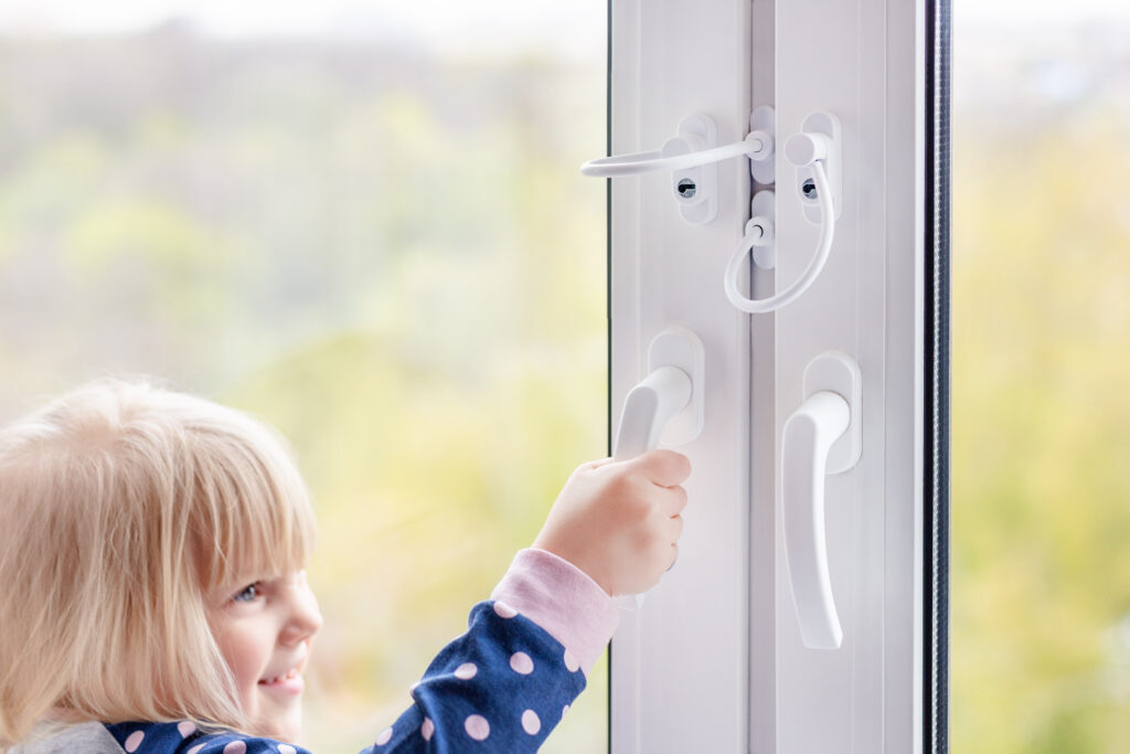 Kind versucht Fenster mit Öffnungsbregenzer zu öffnen