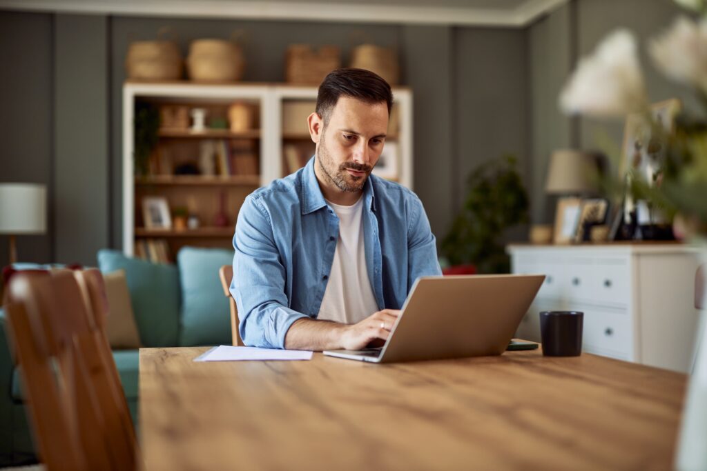 Mann sitzt am Laptop